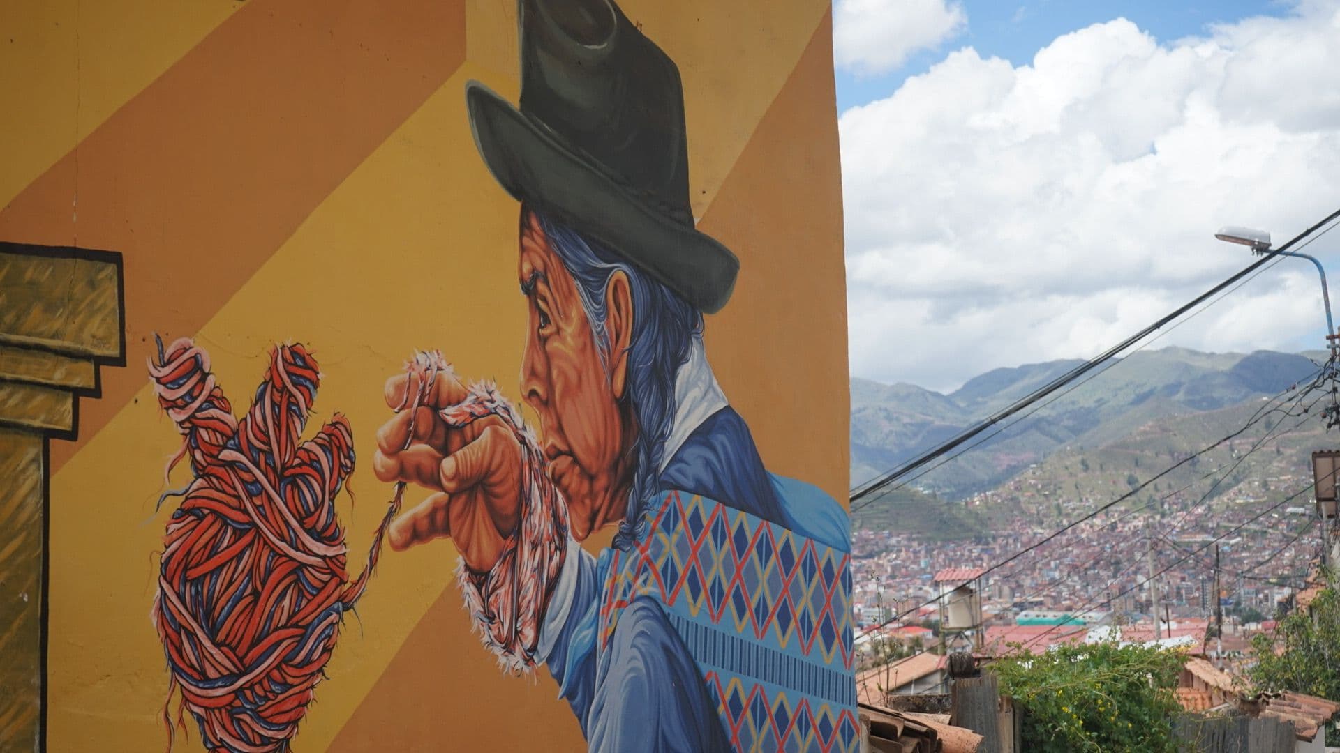 A realistic mural of a person knitting in Peru